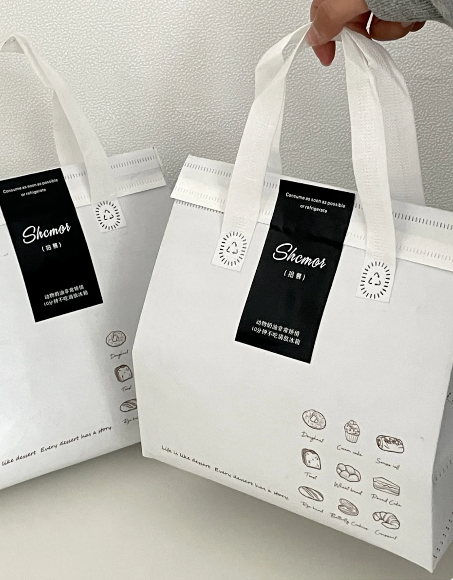Branded tamper-evident adhesive seals applied across takeaway bag closures